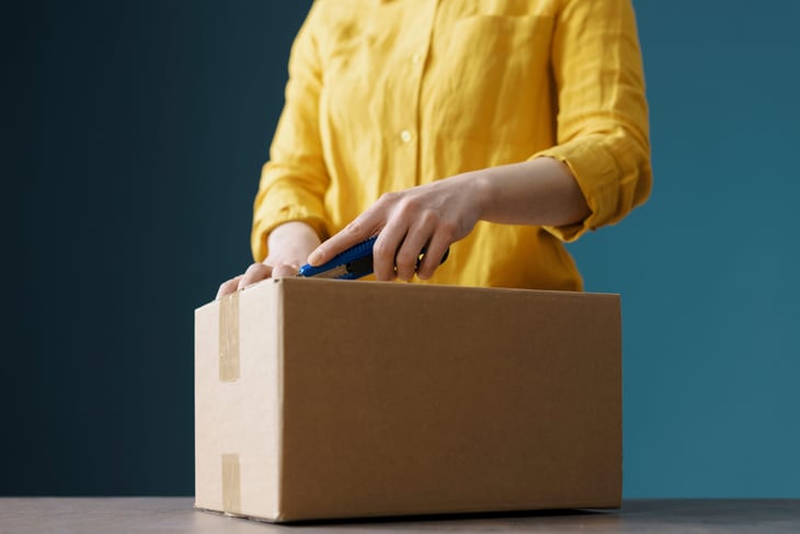 Woman opening a package with box cutters