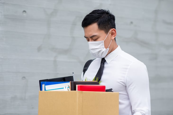 unemployed. out of work. young Asian man white shirt tie box