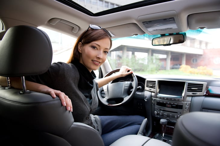 A woman sits in the driver's seat of her car