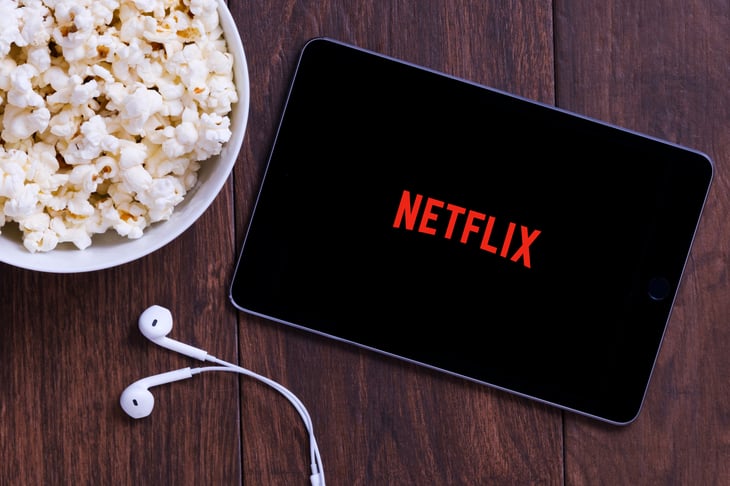 Netflix on a tablet computer with popcorn and earbuds