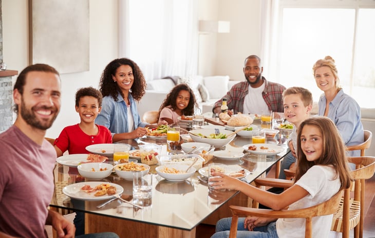 Two Families As They Enjoy Meal At Home Together