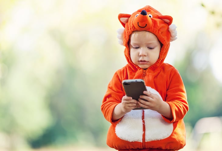 Child in costume with cellphone