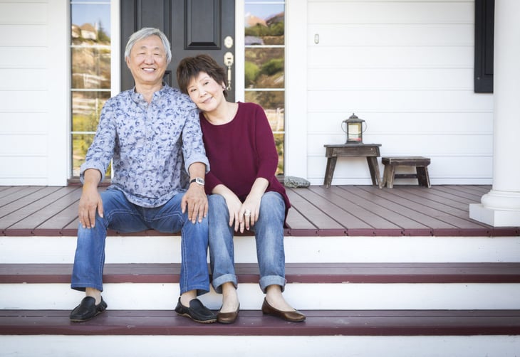 Senior couple in front of their home