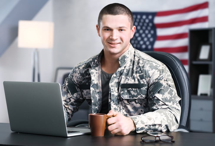 A military veteran works at a laptop
