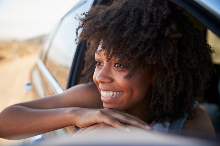 Young woman smiles from a car window