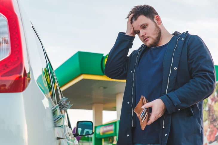 Sad man at gas pump