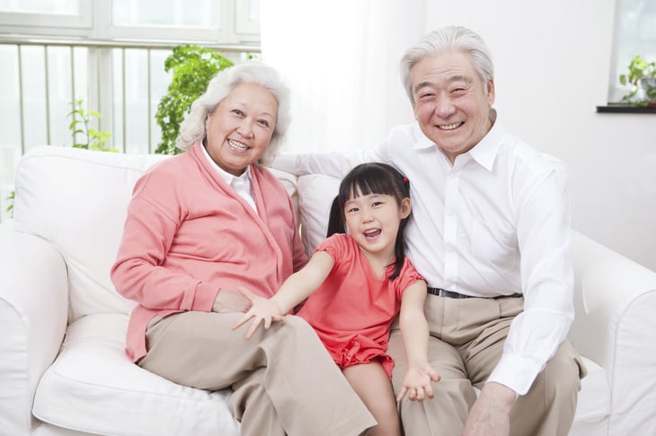 A senior Asian couple with their grandchild