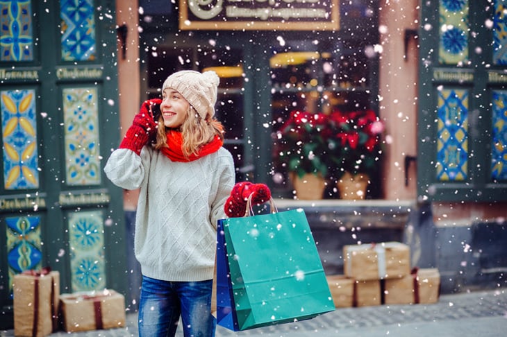 Woman in mittens holding shopping bags