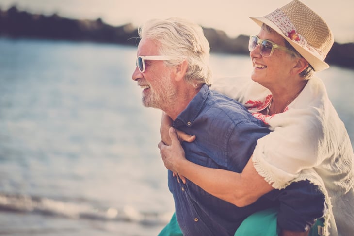 A senior couple in sunglasses enjoys a day at the beach