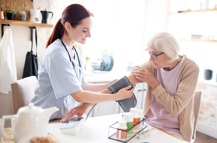 home health nurse taking a senior's blood pressure