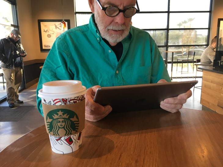 Man using Apple iPad at Starbucks Store