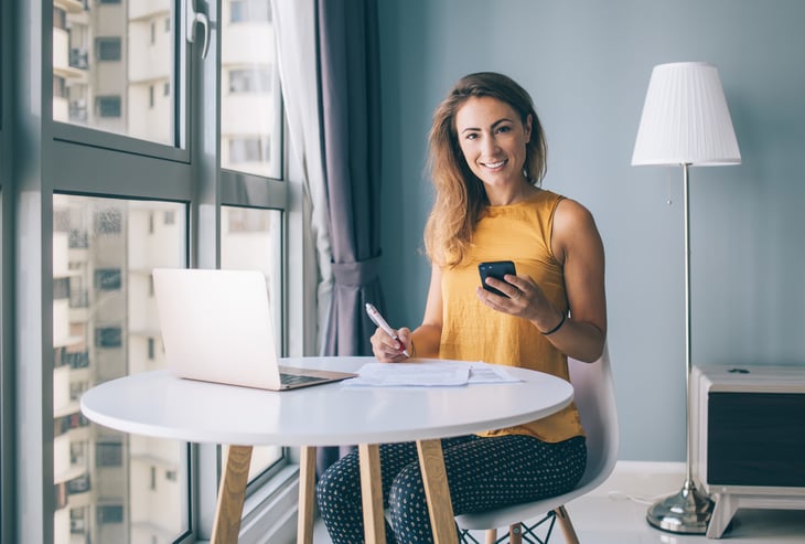 Woman working from home on computer and phone