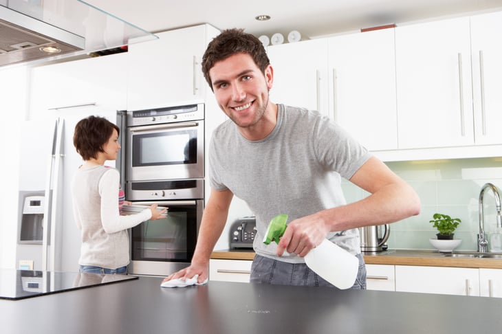 A couple cleans their kitchen
