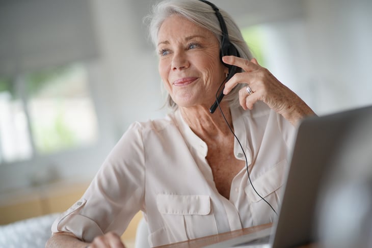 Older woman on phone, with computer