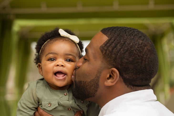 father kissing his little girl