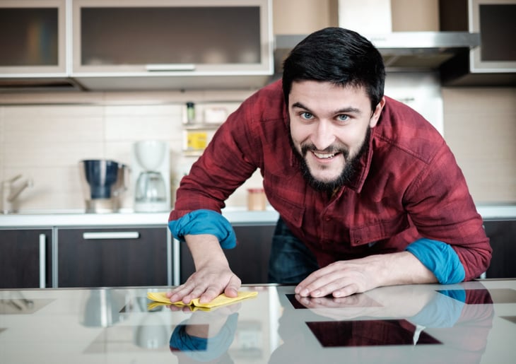A man cleans a kitchen counter