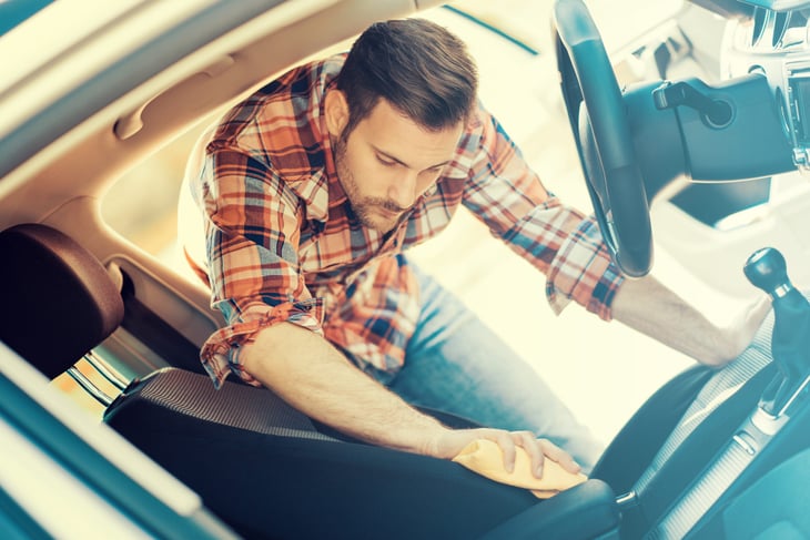 Young man cleaning his car
