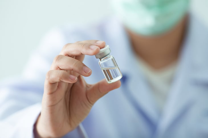 A doctor holds a vaccine in a vial