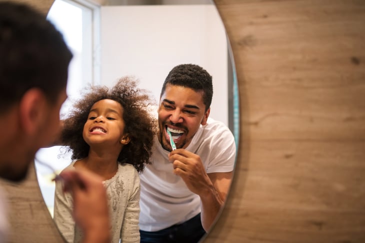 a father brushses his teeth