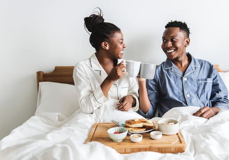couple eating breakfast in bed
