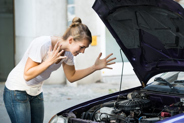 Frustrated woman with broken down car