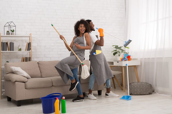 A man and woman having fun while cleaning