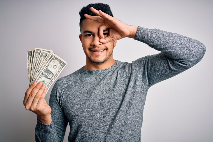 Man holding money and making OK sign
