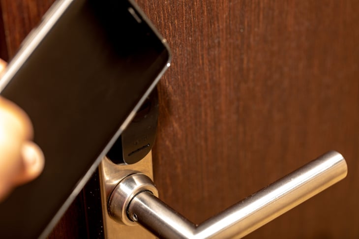 Someone unlocking their hotel room door with a smartphone