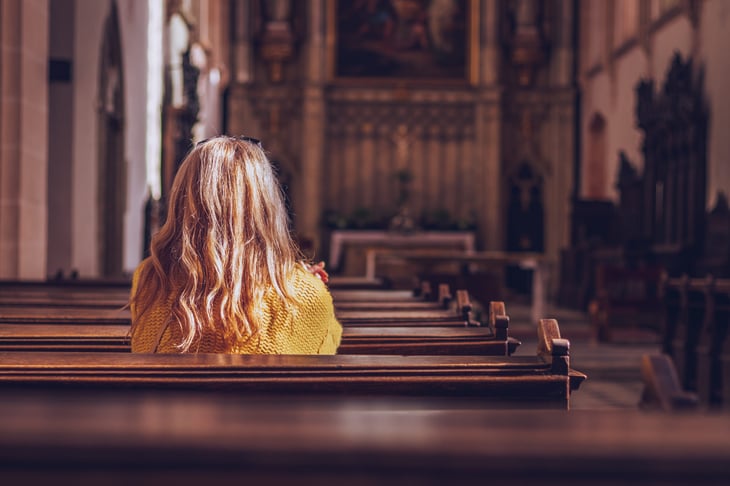 A woman sitting in an empty church