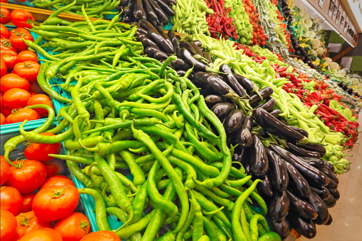 A variety of colorful vegetables at the market, including tomatoes, peppers and eggplant