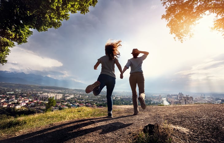 A happy couple runs off to explore the outdoors during the coronavirus crisis
