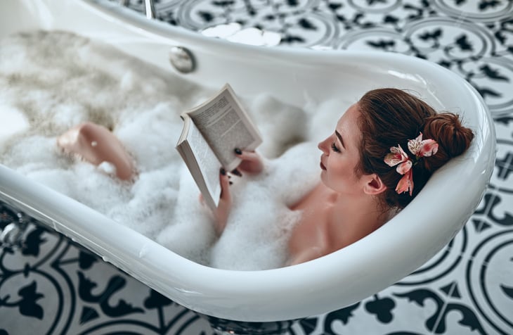 Woman reading in a bubble bath