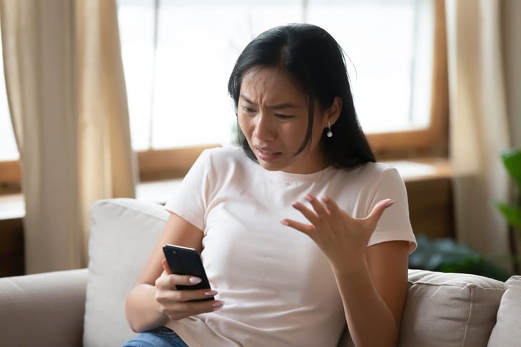 Upset woman looking at her phone