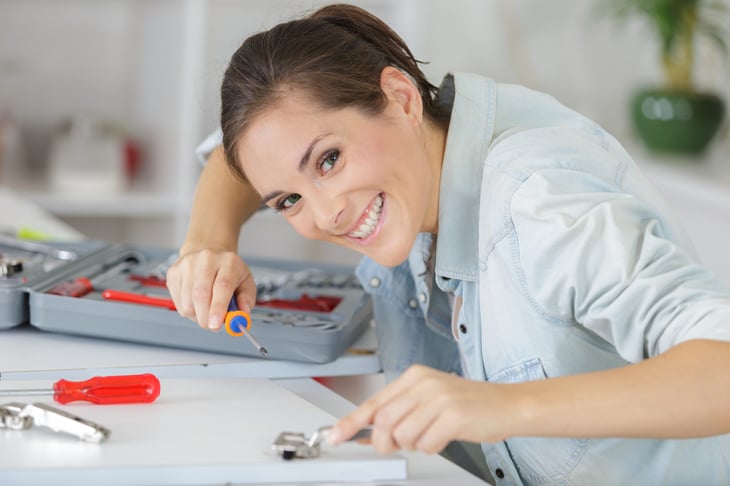 woman installing new hardware on a cabinet door
