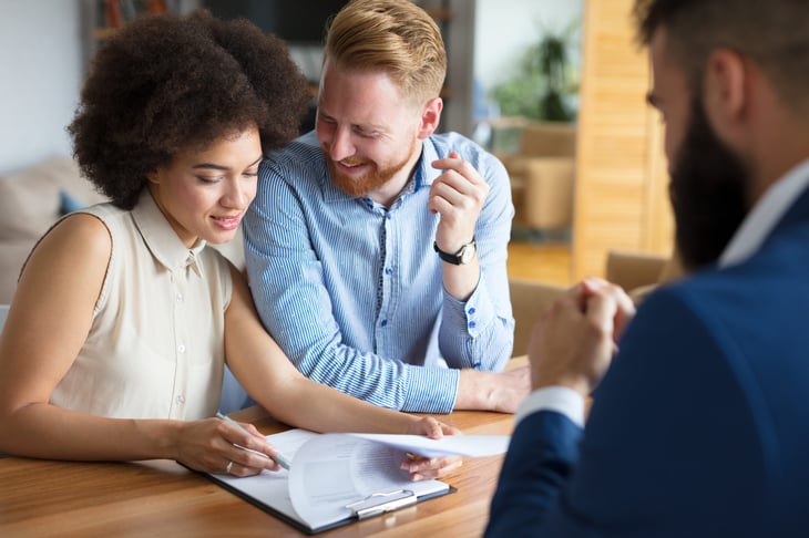 A young couple reviews a mortgage document