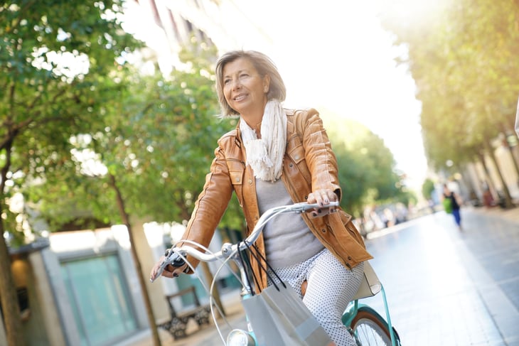 A happy woman riding a bike in a city