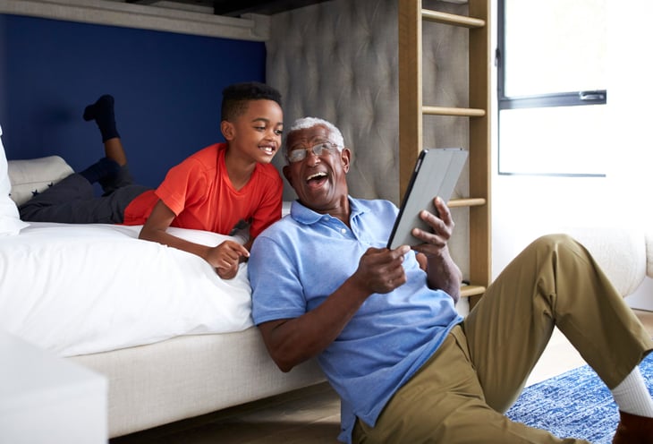 Grandfather using a tablet with his grandchild