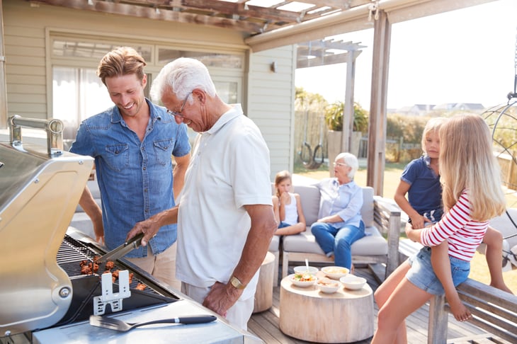 Family grilling on the deck of their home