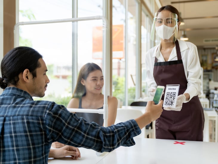 Man scanning a QR code with his smartphone for a restaurant menu
