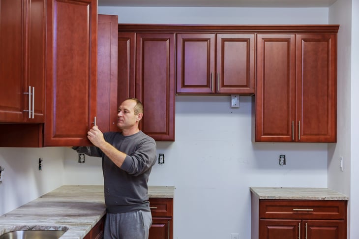 Carpenter putting in kitchen cabinets
