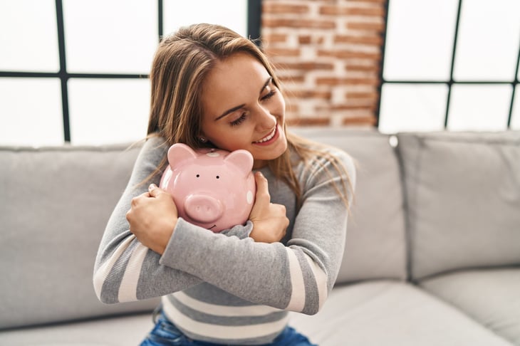 Woman hugging a piggy bank