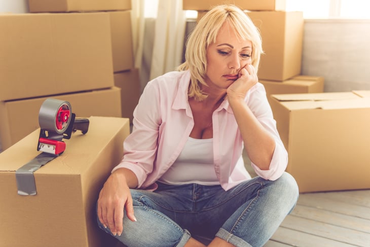 Upset woman packing moving boxes