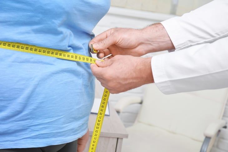 Doctor measuring waistline