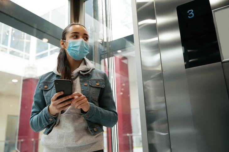 Masked woman alone in an elevator
