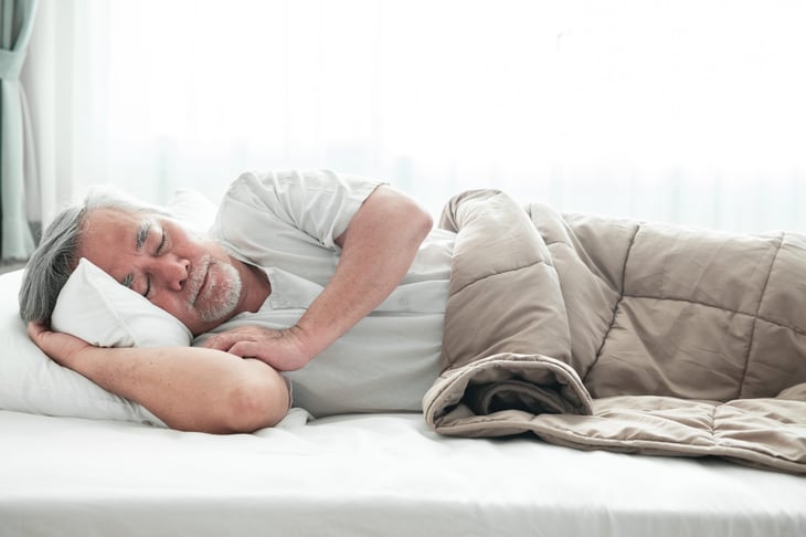 Man sleeping with a weighted blanket