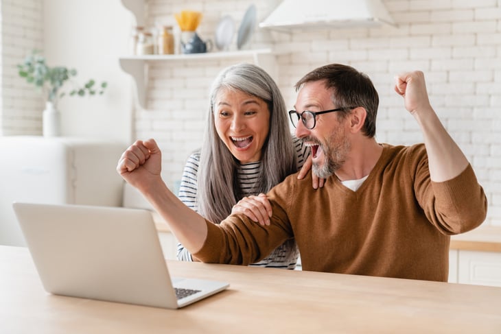 Excited homeowners on a laptop
