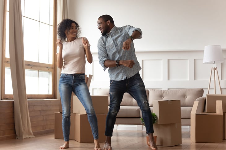 Happy couple moving into their first home and celebrating being new homeowners