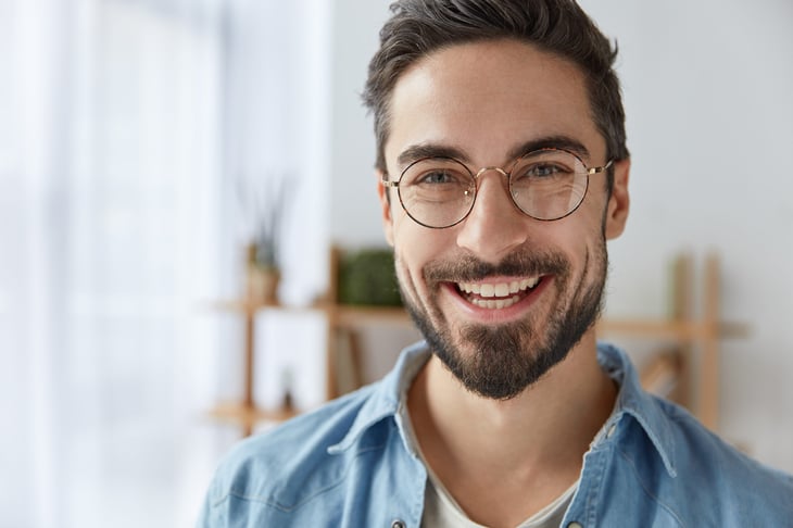Happy young bearded guy with glasses