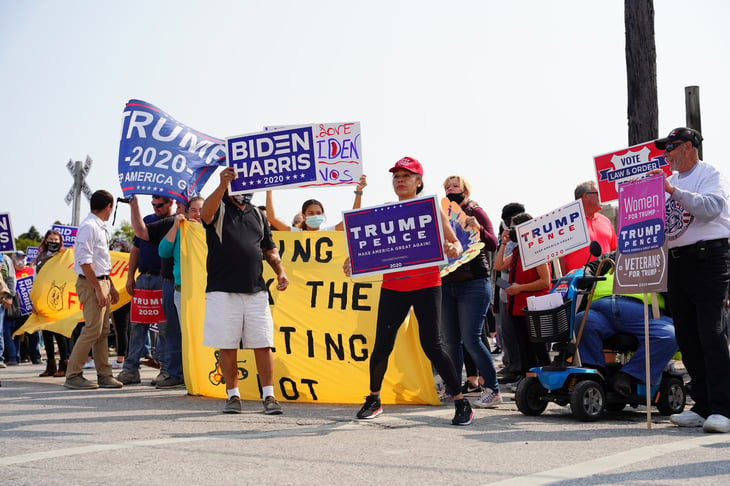 Trump and Biden supporters rally together with signs