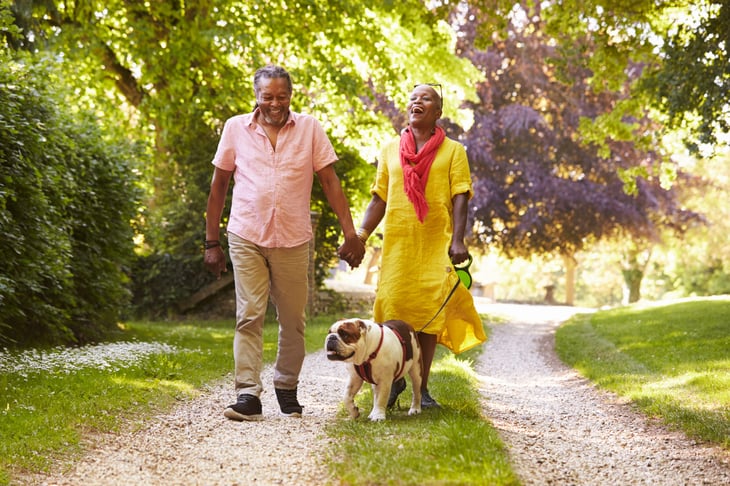 A couple walk on a country road with their dog
